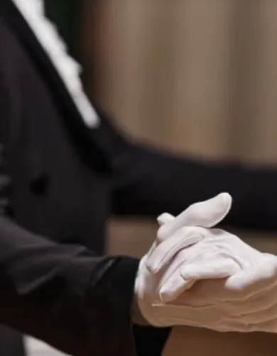 Two white gloves joing hands in dance.